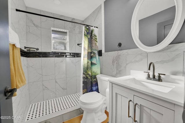 bathroom with vanity, toilet, a shower with shower curtain, and tile walls