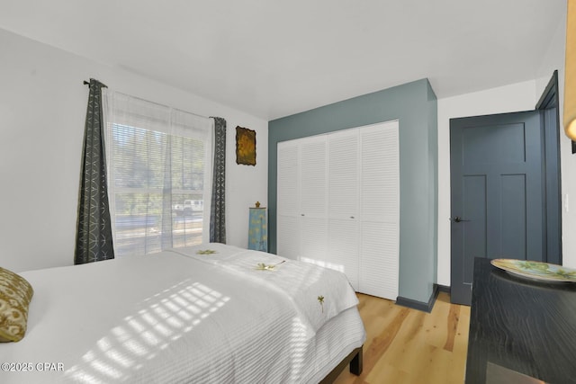 bedroom with light hardwood / wood-style floors and a closet