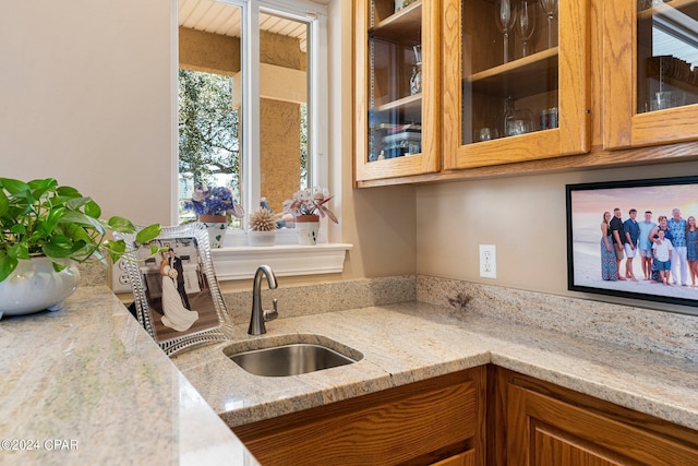 kitchen featuring light stone countertops and sink