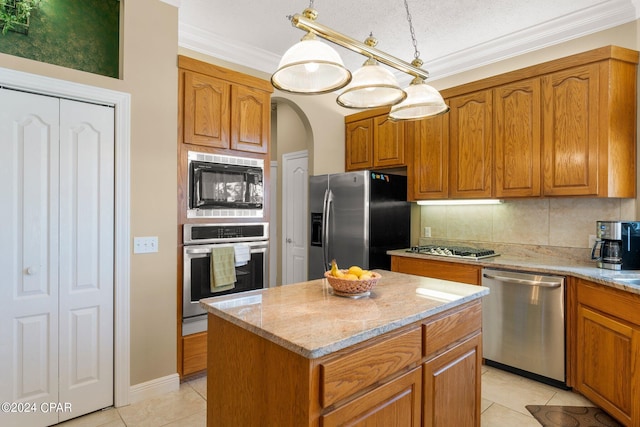 kitchen with a center island, light tile patterned floors, hanging light fixtures, and appliances with stainless steel finishes