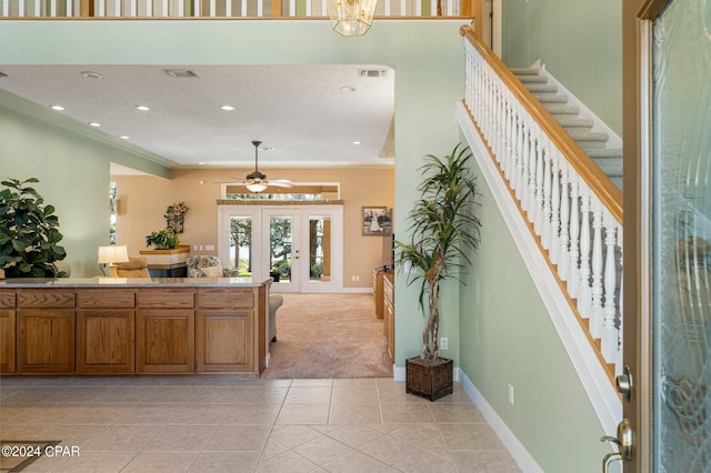 kitchen with ceiling fan, french doors, ornamental molding, and light tile patterned flooring