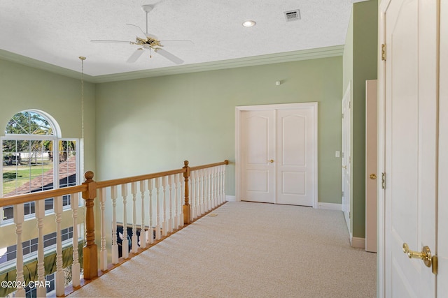 corridor featuring light colored carpet and a textured ceiling