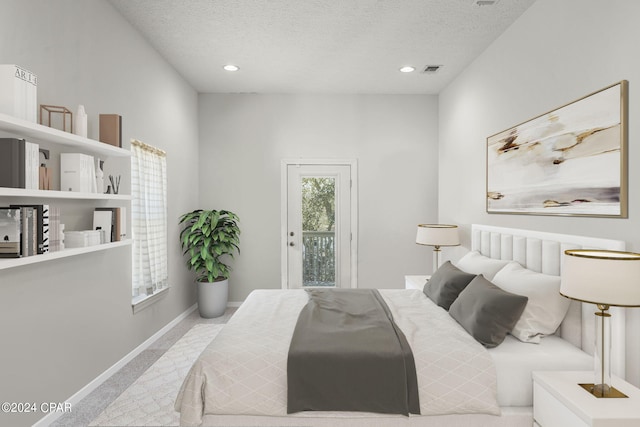 carpeted bedroom with access to exterior and a textured ceiling