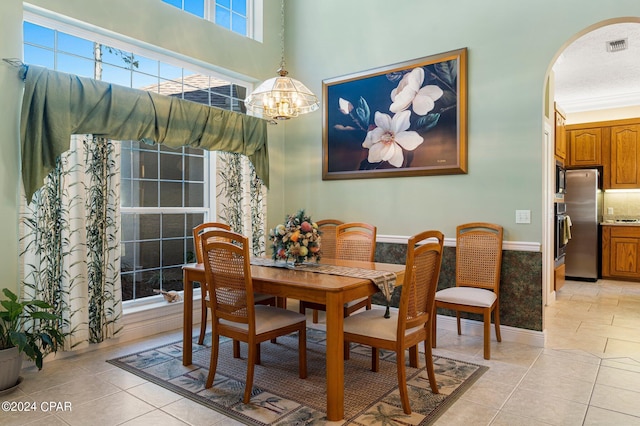 dining area featuring an inviting chandelier, light tile patterned floors, and a wealth of natural light