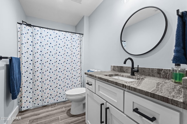 bathroom featuring vanity, curtained shower, and toilet