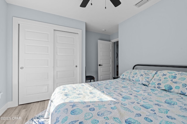 bedroom with ceiling fan, light wood-type flooring, and a closet