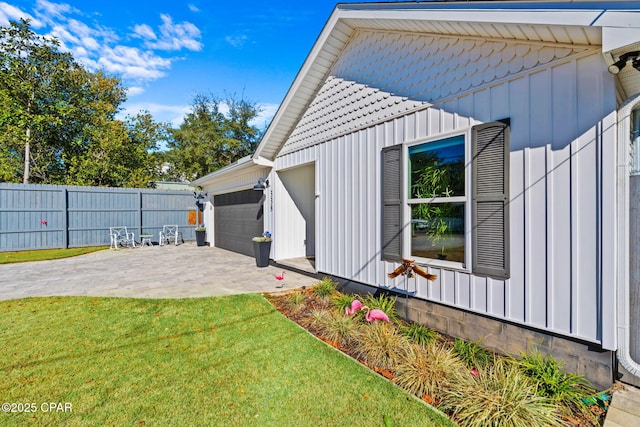 view of side of home with a patio and a lawn