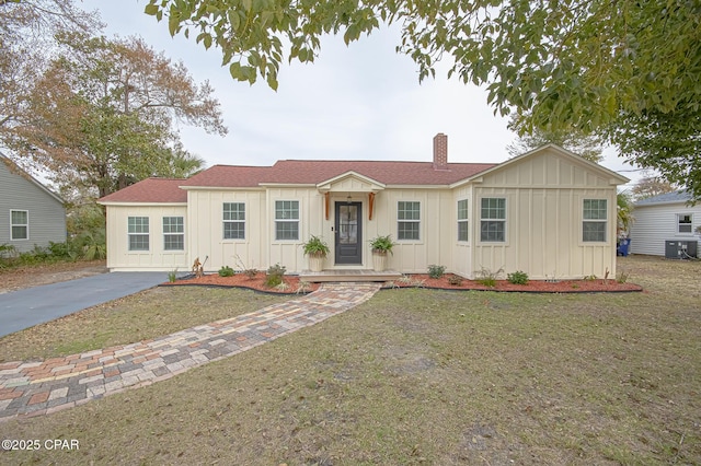 view of front facade with a front lawn and central air condition unit