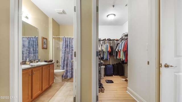 bathroom featuring vanity, wood-type flooring, toilet, and a shower with shower curtain