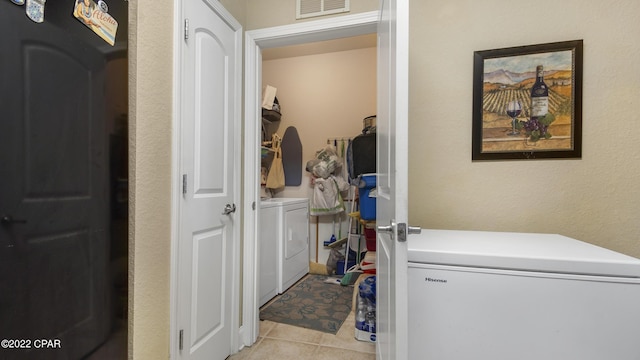 laundry room featuring light tile patterned flooring and washing machine and clothes dryer