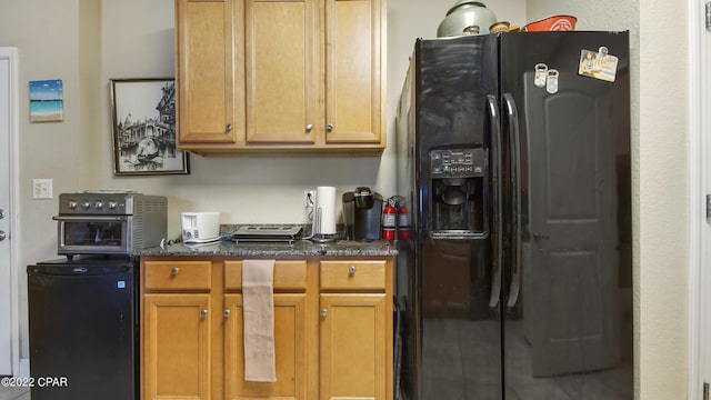 kitchen featuring black refrigerator with ice dispenser