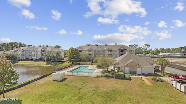 view of swimming pool with a lawn and a water view