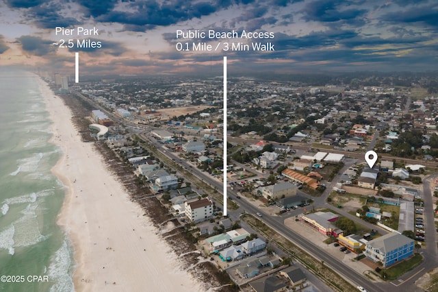 aerial view at dusk with a water view and a view of the beach