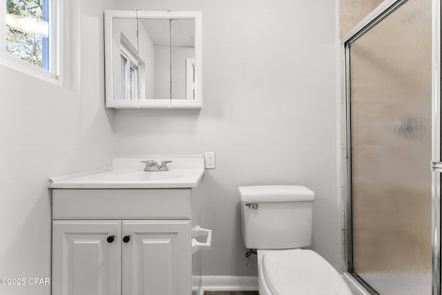 bathroom featuring vanity, an enclosed shower, and toilet