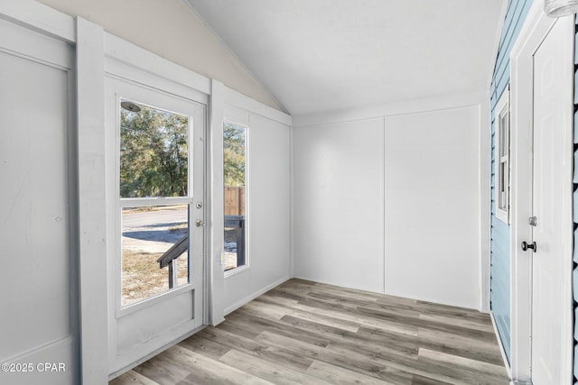 unfurnished sunroom featuring lofted ceiling and a wealth of natural light