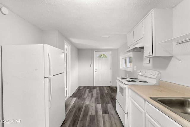 kitchen with dark wood-type flooring, a textured ceiling, white cabinets, and white appliances