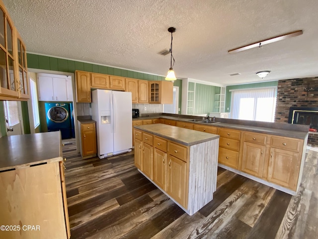 kitchen with a center island, sink, hanging light fixtures, and white fridge with ice dispenser