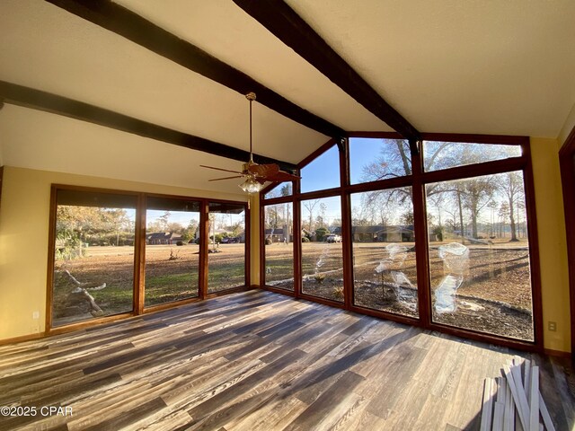 unfurnished sunroom featuring a rural view and vaulted ceiling with beams