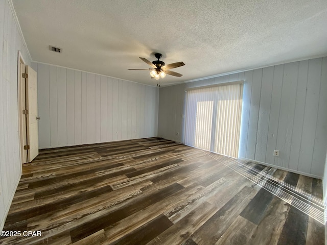 unfurnished room with ceiling fan, crown molding, dark hardwood / wood-style floors, and a textured ceiling