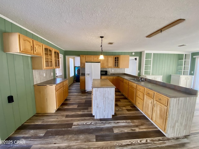 kitchen with dark hardwood / wood-style floors, decorative light fixtures, a kitchen island, and white fridge with ice dispenser