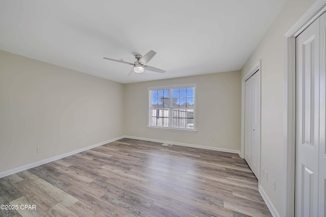 unfurnished bedroom with ceiling fan and light wood-type flooring