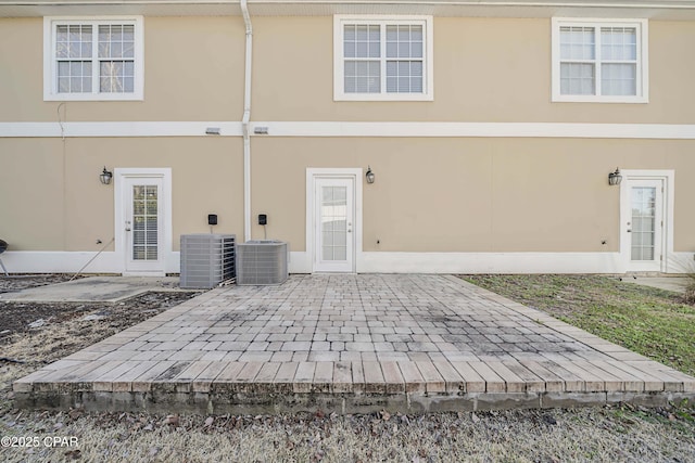 rear view of house featuring central AC unit and a patio area