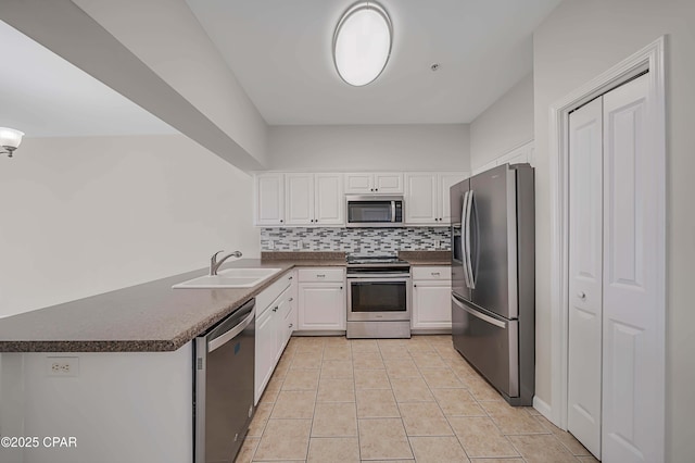 kitchen featuring stainless steel appliances, white cabinetry, sink, and kitchen peninsula