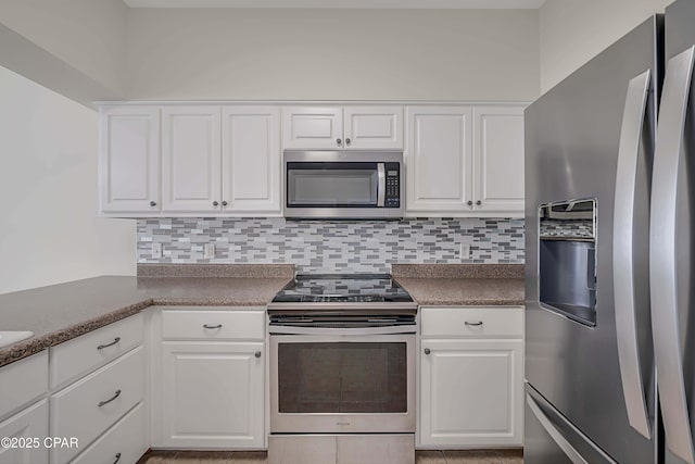 kitchen with stainless steel appliances, white cabinetry, tasteful backsplash, and light tile patterned floors