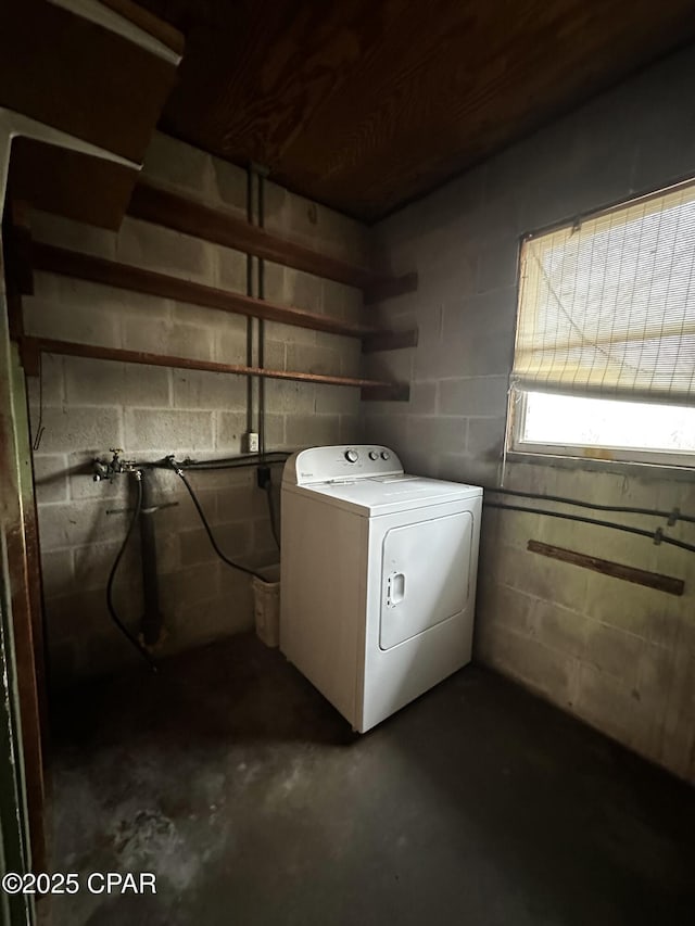 washroom featuring concrete block wall and washer / dryer