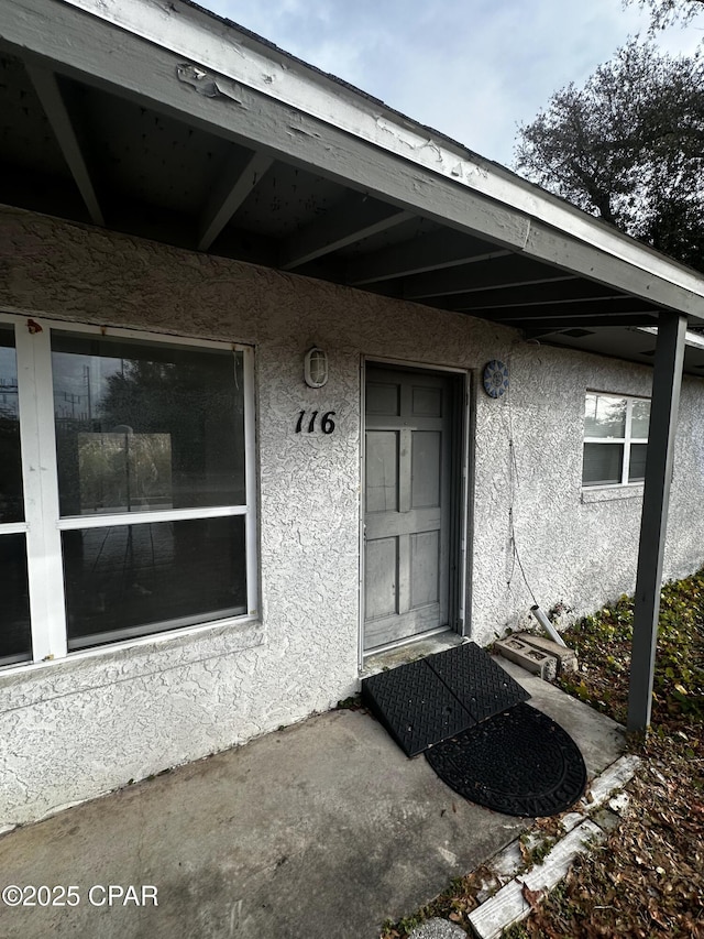 doorway to property with stucco siding