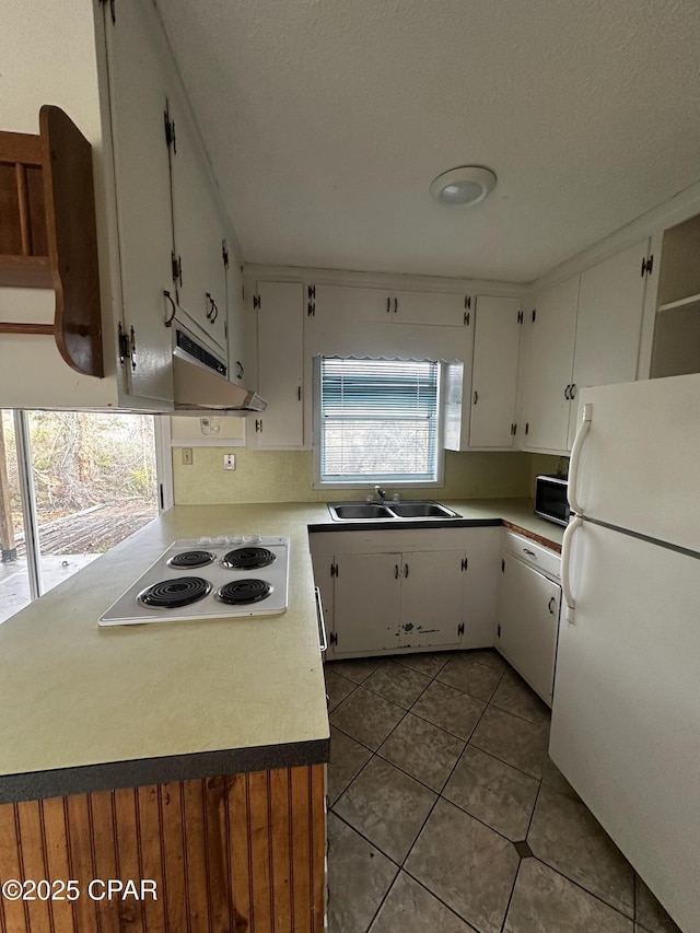 kitchen featuring light countertops, white appliances, white cabinets, and a sink