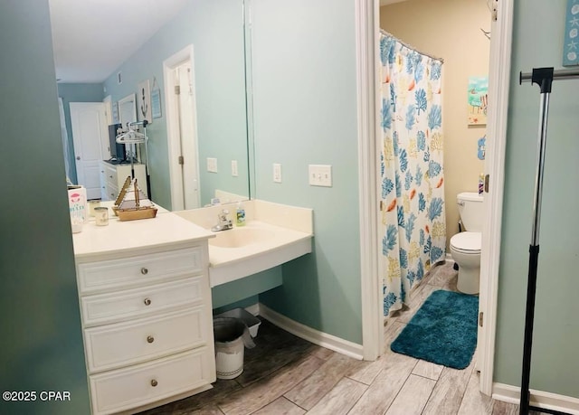 bathroom with vanity, curtained shower, and toilet