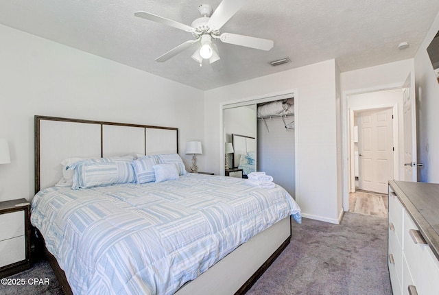 carpeted bedroom with ceiling fan, a textured ceiling, visible vents, and a closet