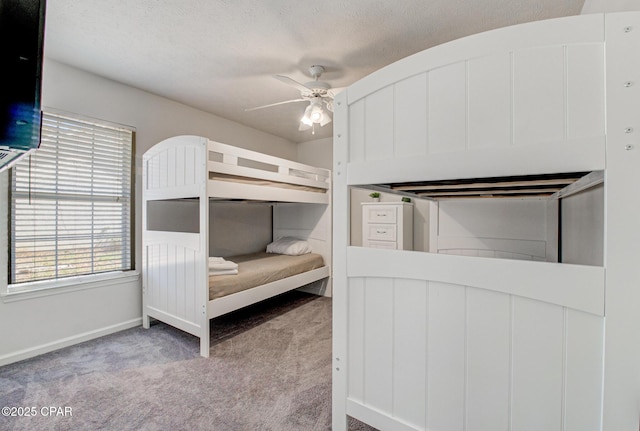 unfurnished bedroom with carpet flooring, a ceiling fan, baseboards, and a textured ceiling