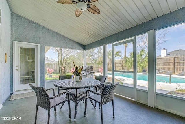 sunroom featuring outdoor dining space and a ceiling fan