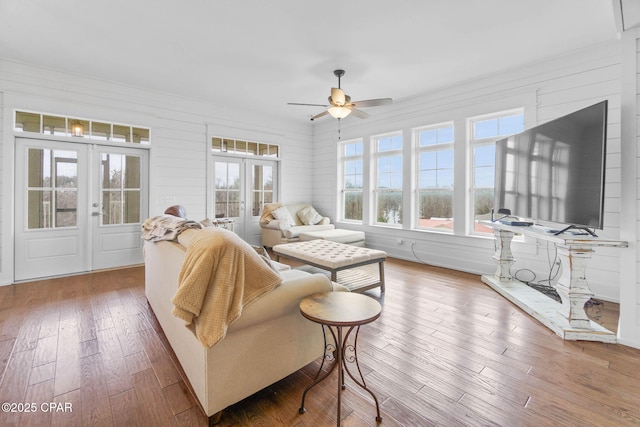 living room featuring hardwood / wood-style floors, ceiling fan, and french doors