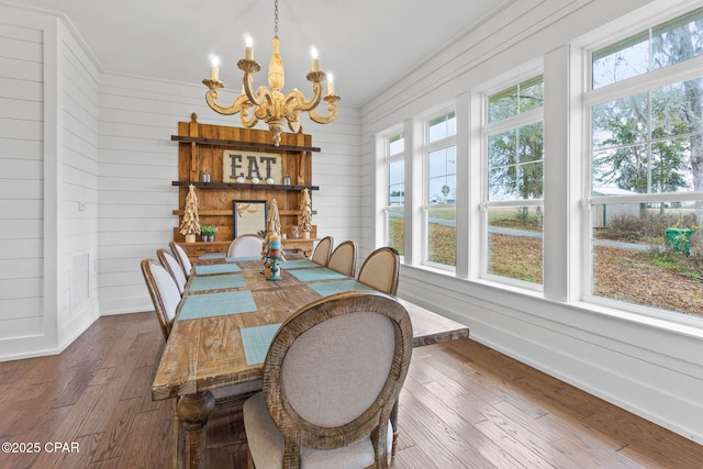 dining room with crown molding, a notable chandelier, hardwood / wood-style floors, and a wealth of natural light