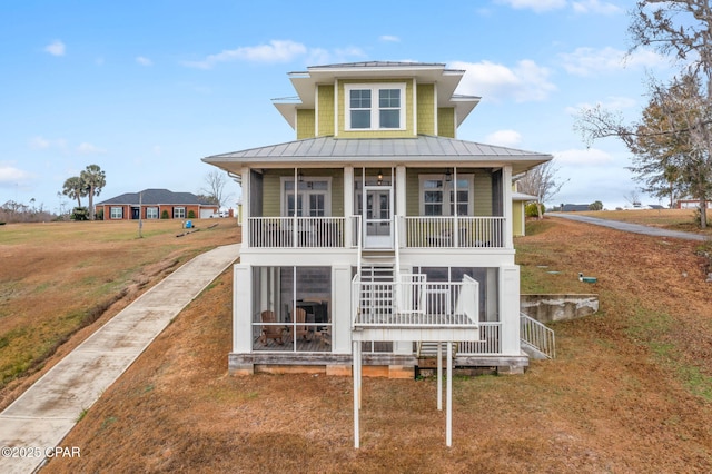 rear view of house with a yard, a sunroom, and covered porch