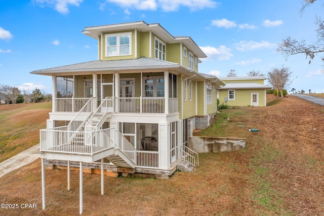 rear view of house with a sunroom and a lawn