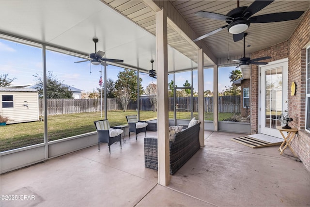 unfurnished sunroom with ceiling fan