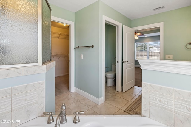 bathroom featuring tile patterned floors, toilet, and a bathing tub