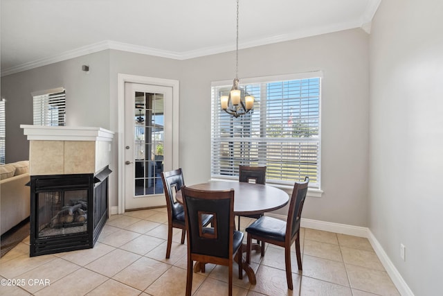 tiled dining room with ornamental molding, a fireplace, and an inviting chandelier