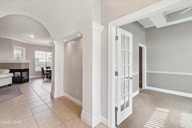 hall featuring ornamental molding, light tile patterned floors, and ornate columns