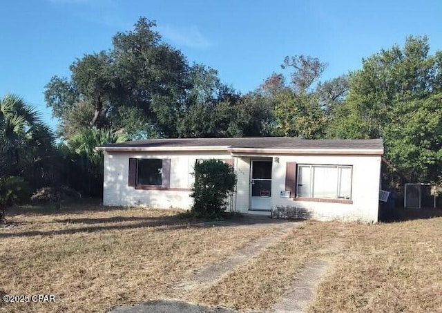 single story home featuring a front lawn