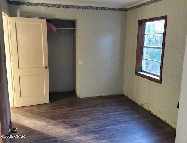 unfurnished bedroom with hardwood / wood-style flooring and a closet