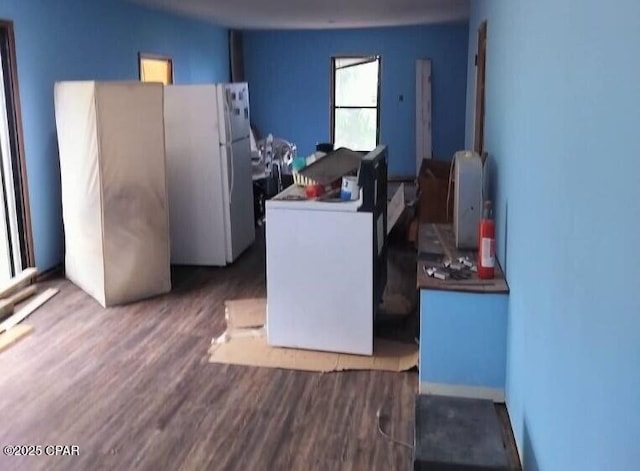 kitchen with white cabinetry, white refrigerator, fridge, washer / clothes dryer, and hardwood / wood-style floors