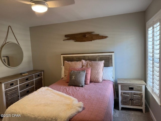 bedroom with ceiling fan and dark colored carpet