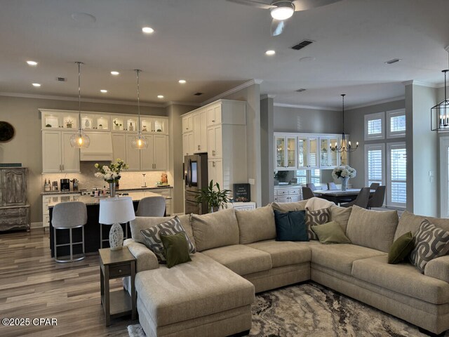 dining area featuring ornamental molding, hardwood / wood-style floors, and an inviting chandelier