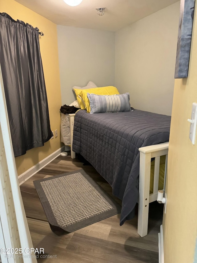 bedroom featuring wood finished floors and baseboards