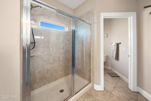 bathroom featuring walk in shower, tile patterned floors, and toilet